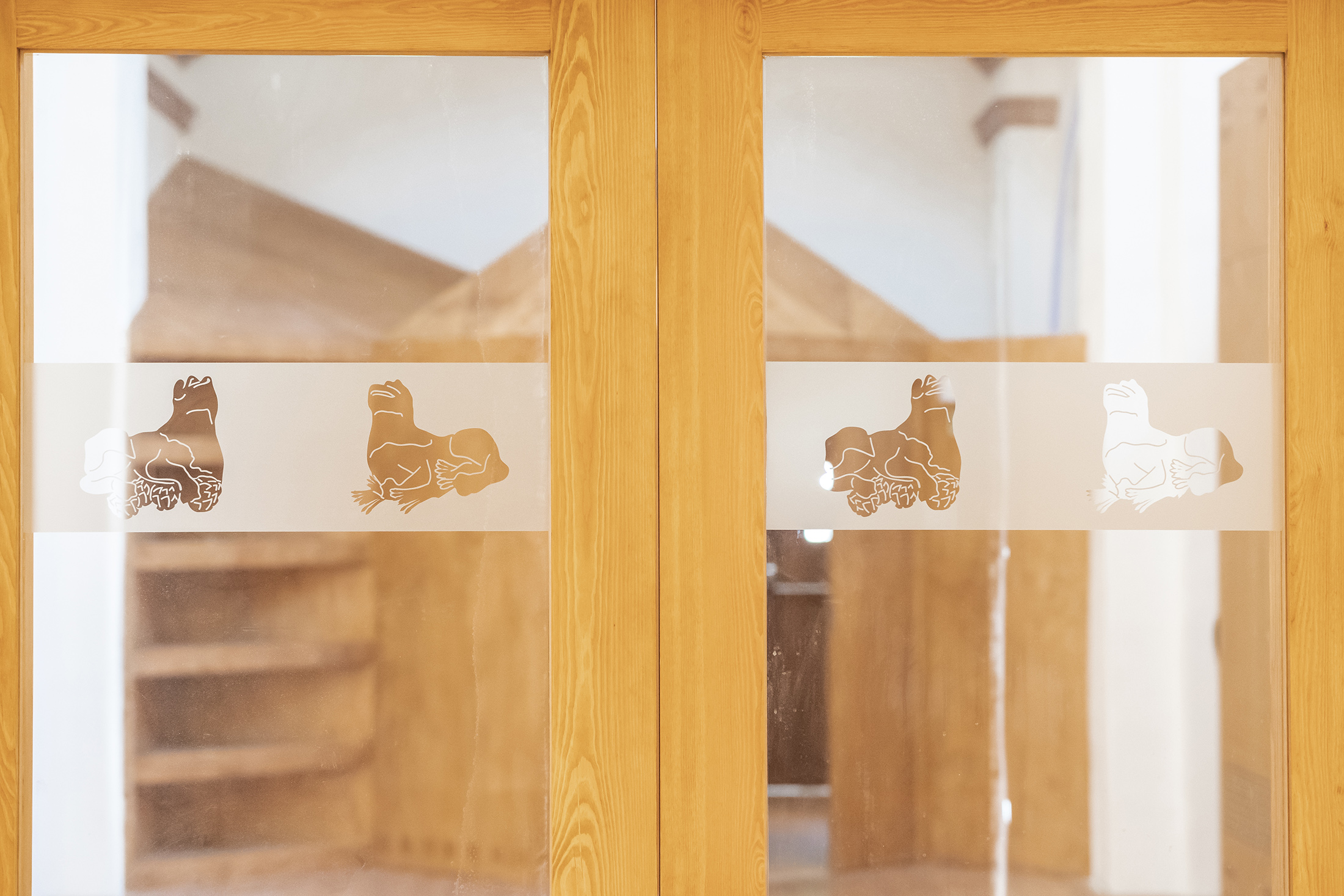 Detalle de las puertas interiores de madera con grabados translúcidos en el cristal